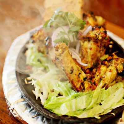 Grilled marinated chicken drumsticks served over a salad.