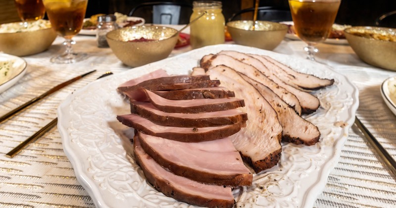 Smoked turkey and ham plate on a table with food and drinks