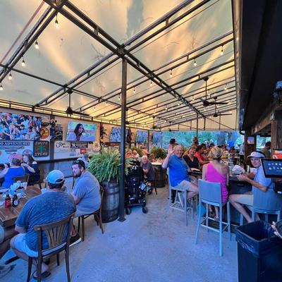 Outdoor bar with people sitting at table.