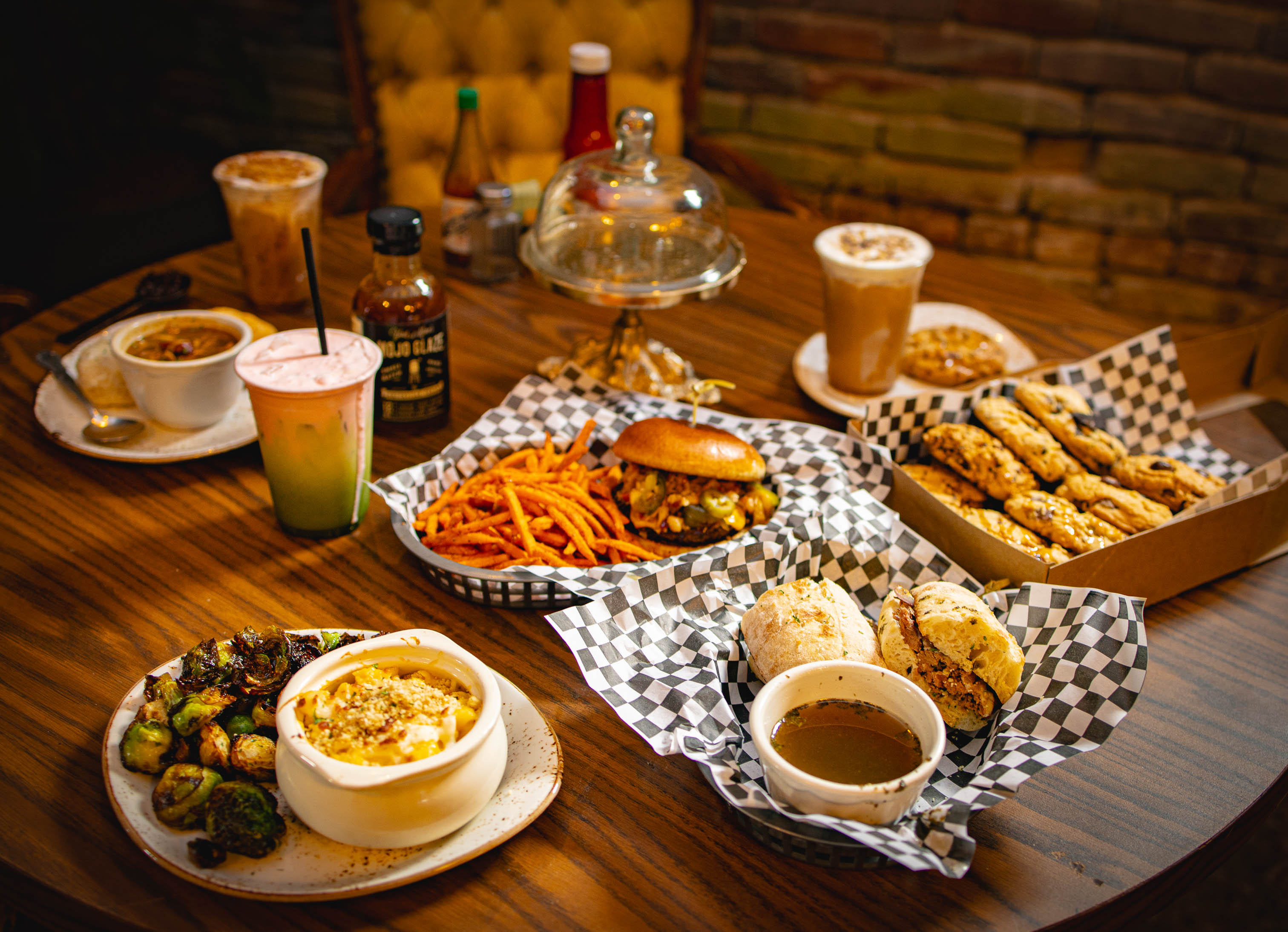 A variety of comfort food and colorful iced drinks served on a wooden table