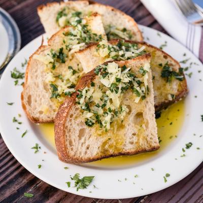 Bread slices topped with olive oil, garlic and chopped parsley.