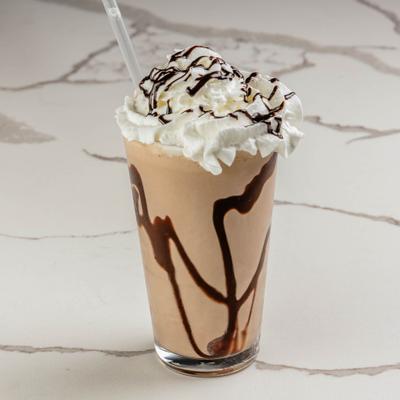 Chocolate milkshake topped with whipped cream and drizzled with chocolate sauce.
