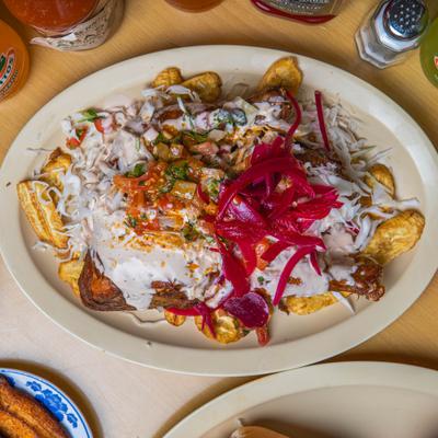 Loaded fries topped with meat onions and crema.