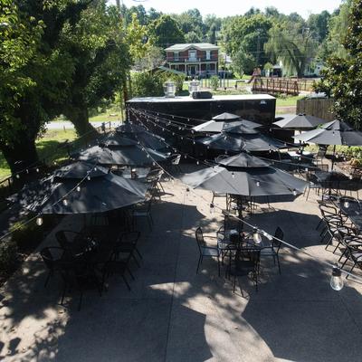 Outdoor seating area, tables covered by parasols.