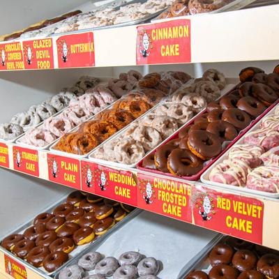 Pastry case shelves filled with a variety of donuts.