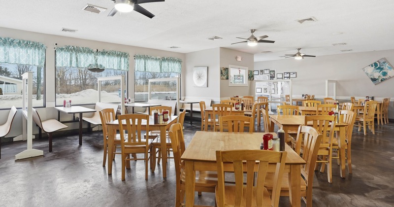 Interior, dining area, wooden tables and chairs, seating booths in the back, ceiling fans