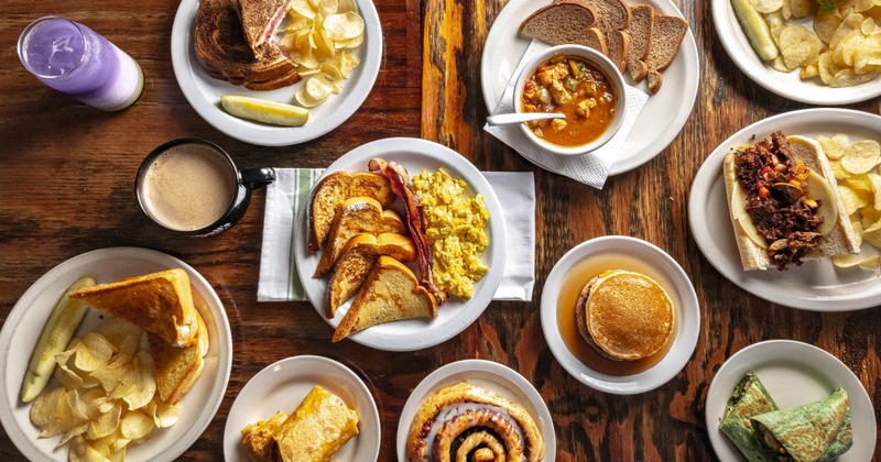 Assortment of food dishes spread on a wooden table, overhead view