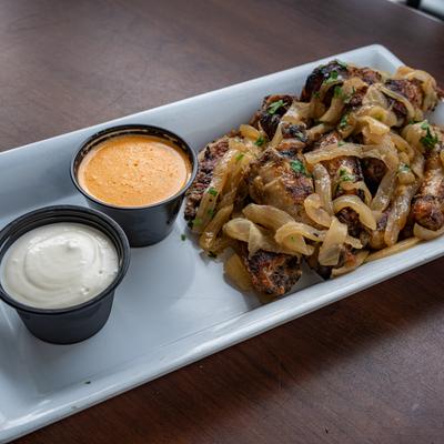 Oven Roasted Chicken Wings, served alongside two dipping sauces.