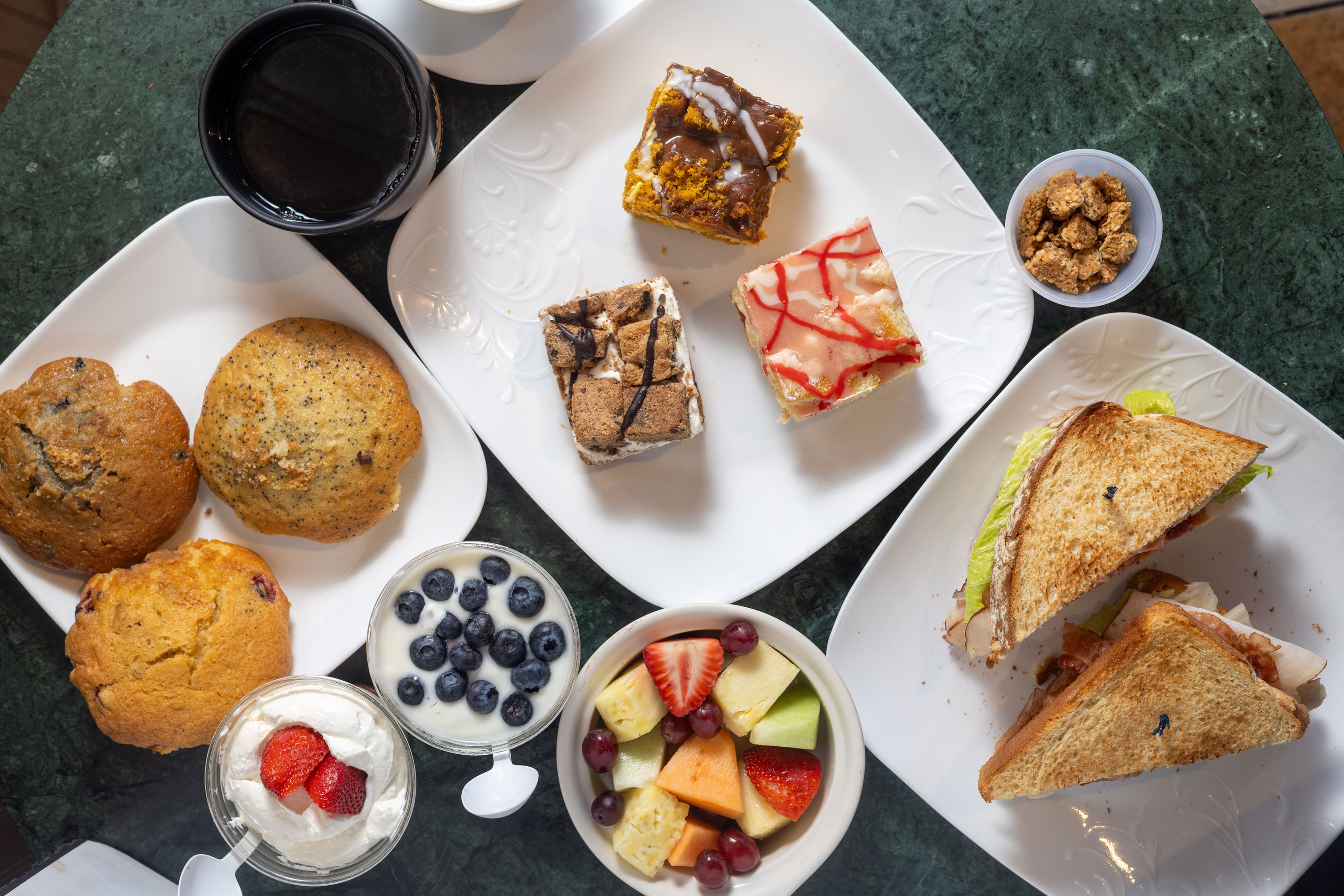 Variety of pastries, sandwiches and dessetrs served on the table