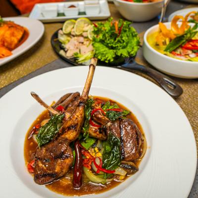 Basil Lamb Chops served on the table alongside other menu items.