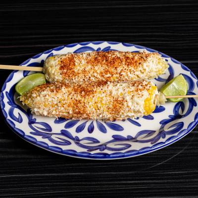 Mexican-style street corn served with lime wedges