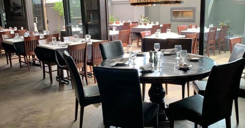 Empty dining room at restaurant with neatly set tables and chairs, waiting for guests to arrive