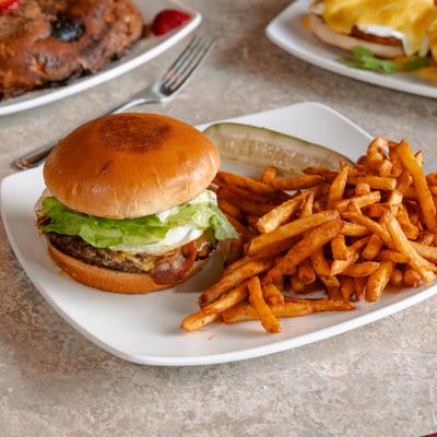 Sophia's Burger served with a side of fries and a pickle spear.
