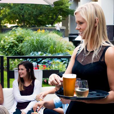 A server carrying tray with drinks in the patio.