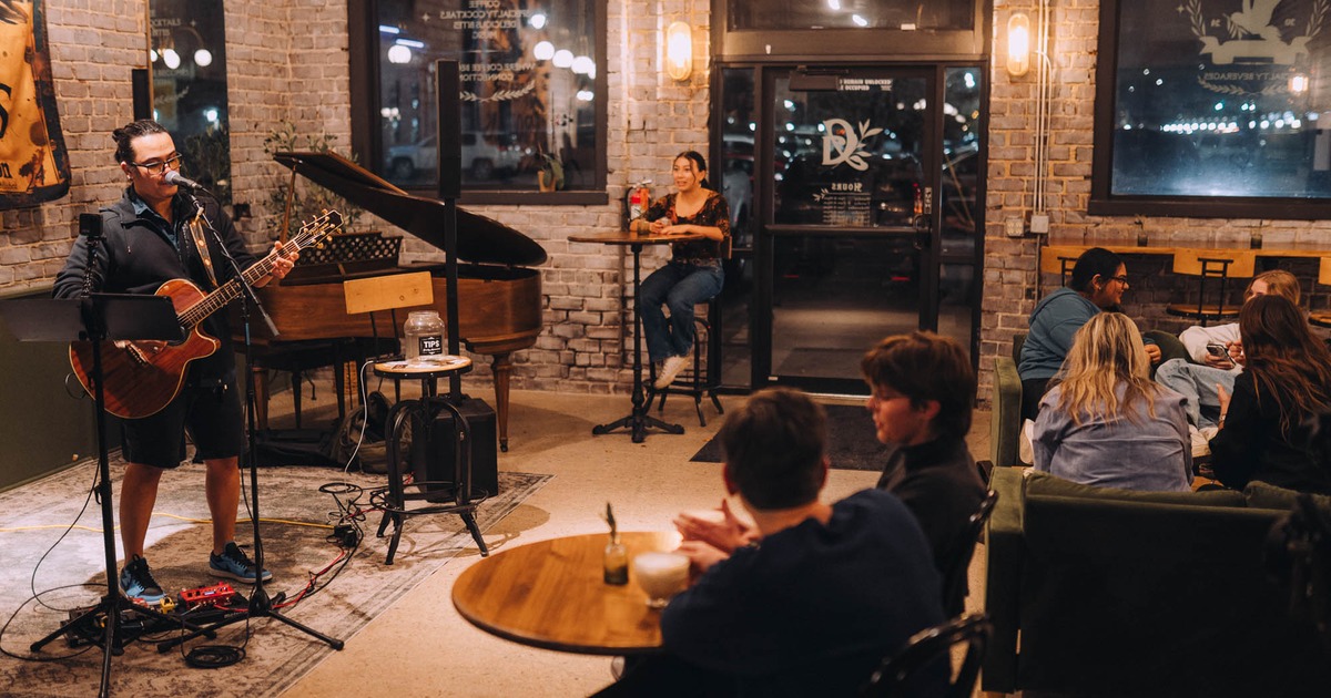 Guests seated at tables enjoying live music and coffee
