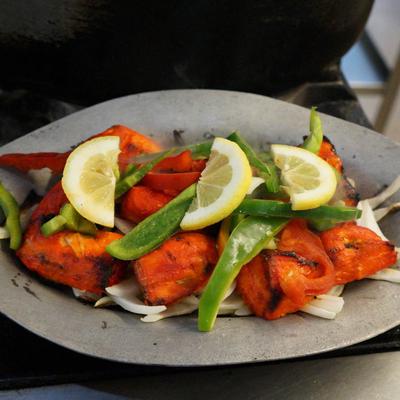 Chicken tikka with fresh green peppers, onion and lemon slices on top
