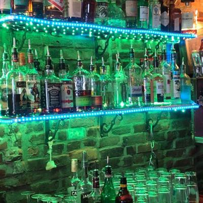 Interior, bar area with drinks on shelf, neon lights