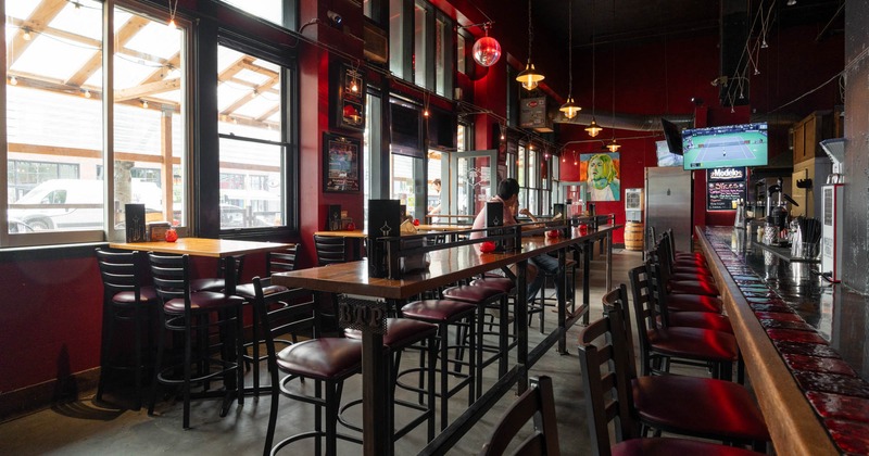 Interior, bar and high seating area, wooden top tables with stools, bar entrance