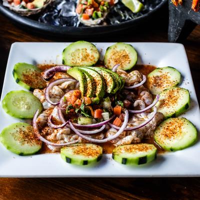 Aguachile topped with avocado, red onions, fresh salsa, and cucumbers.