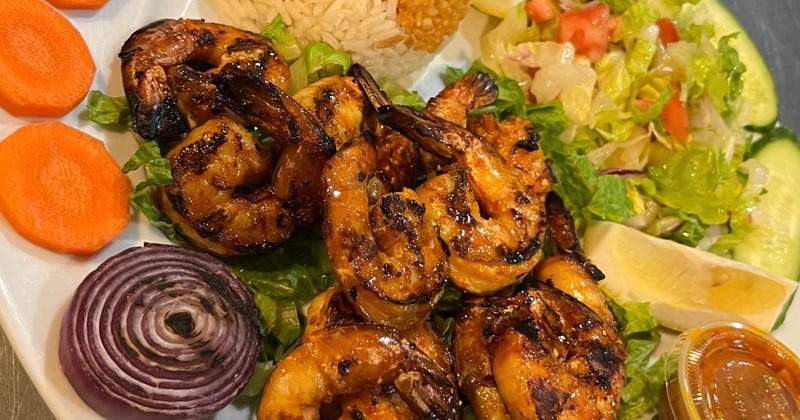 Grilled shrimp platter with rice and fresh vegetables