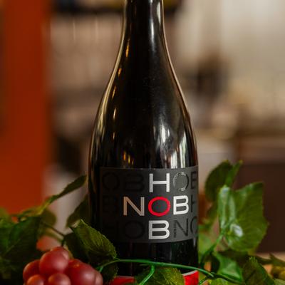 Bottle of red wine featuring white and red lettering stacked on a black label.