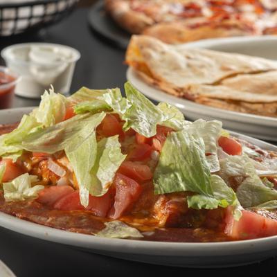Burrito smothered in red sauce, topped with lettuce and tomato.