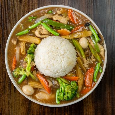 Vegetable curry served with a mound of rice in a bowl.