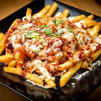 Fries topped with sauce and melted cheese.
