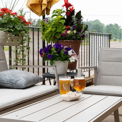 Patio seating with served beers and popcorn on the table.