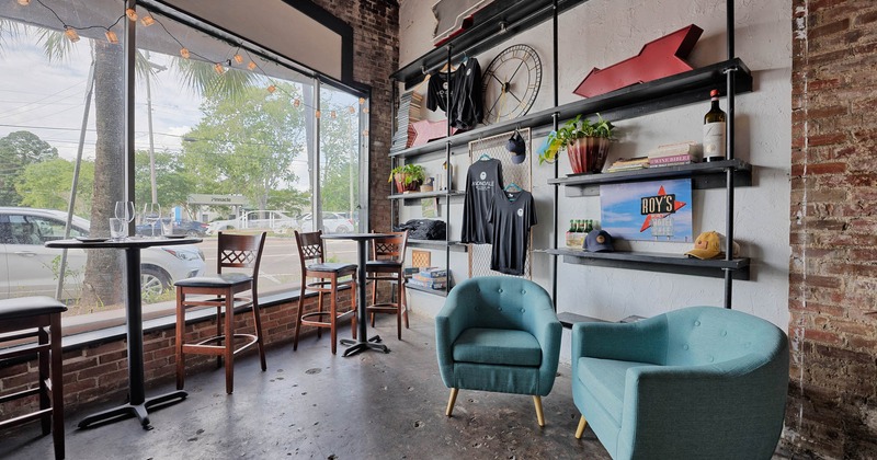 Interior, tables and seating by a window side, shelves with merchandise items