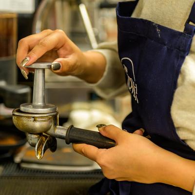 Employee pressing coffee.