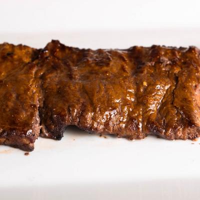 Grilled beef strip on a white plate.
