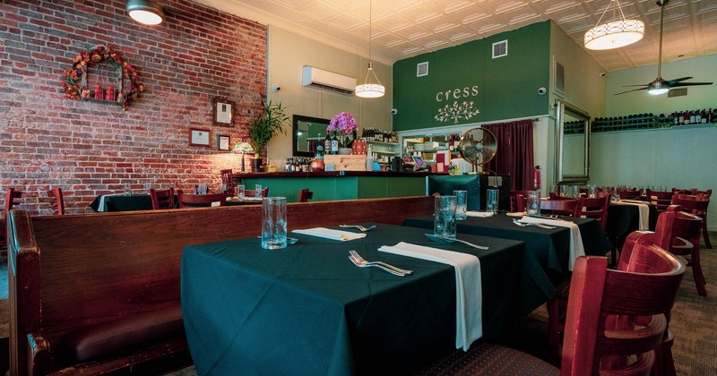 Interior, table for two by a brick wall, with table cloth and table items