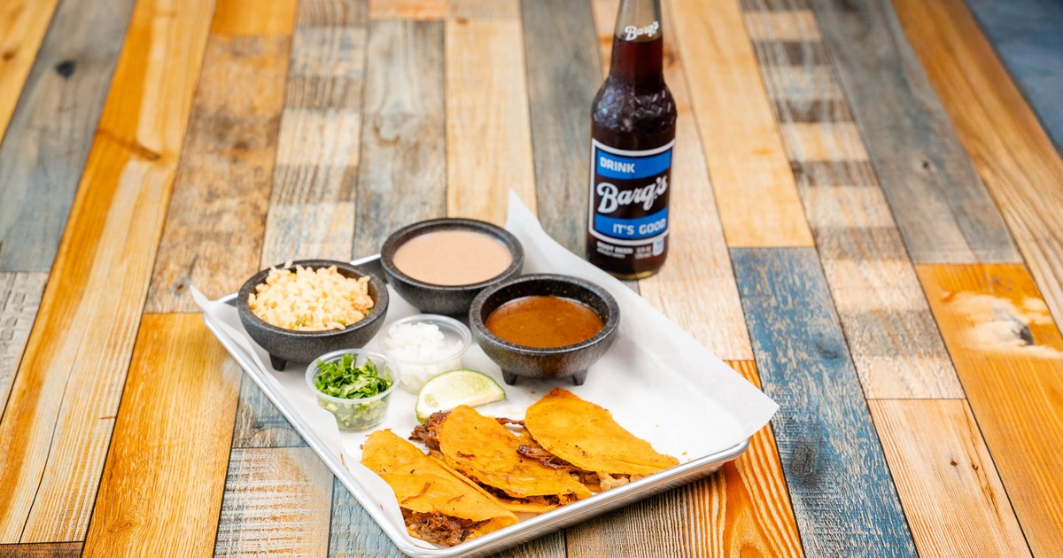 Birria tacos served with side of consomme and other condiments