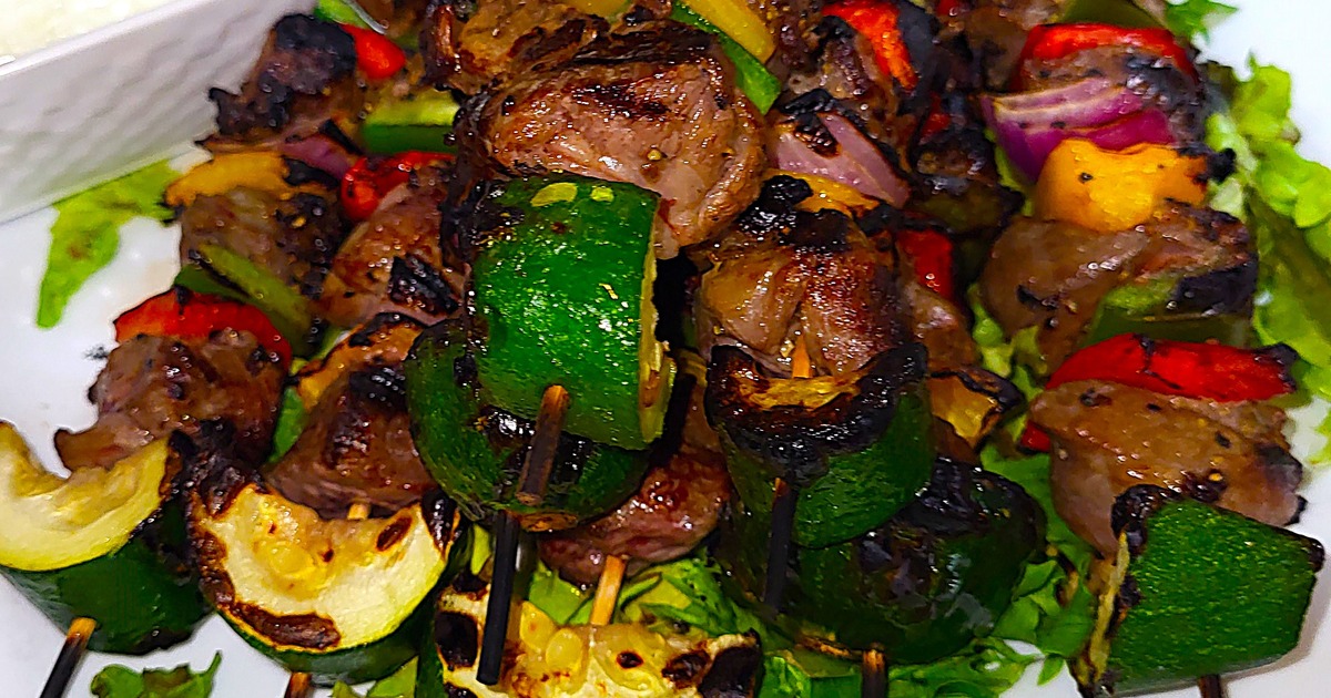 Grilled skewers with juicy beef and veggies on a bed of fresh lettuce