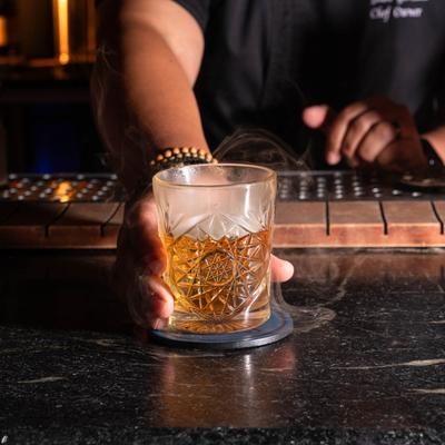 A bartender presenting the Old Fashioned cocktail.