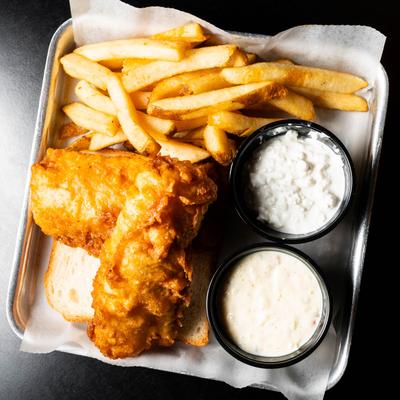 Fried fish filets with fries, coleslaw, and tartare sauce.