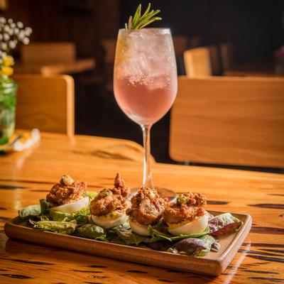 Nuggets with boiled eggs and green salad, cocktail in the back