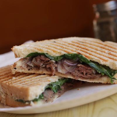 Roast beef sandwich, with red onion, cheese, and spinach.