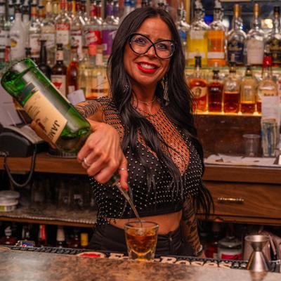 A bartender pouring Irish whiskey into a glass.