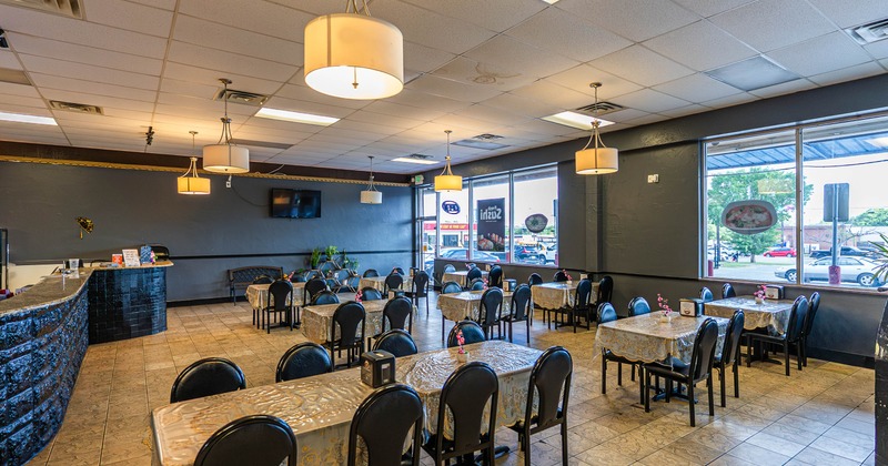Spacious restaurant with neatly arranged tables and black chairs