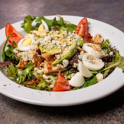 Chicken Cobb salad with hard-boiled eggs, blue cheese crumbles and fresh vegetables.