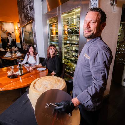 Employee carrying a cheese wheel.