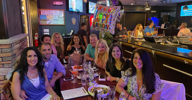 Interior, seated guests smiling while posing for the photo