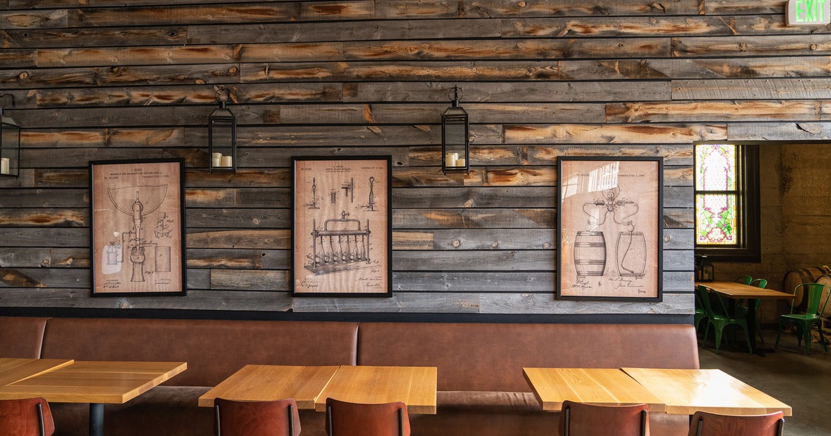 Interior, tables, chairs and seats, framed drawings on the wall behind seats