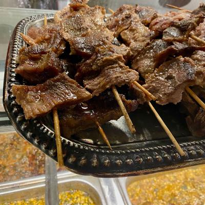 Grilled beef skewers served on a platter.