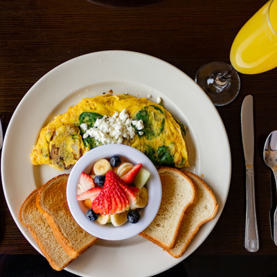 Garden omelet with spinach and goat cheese, served with fresh fruit and toast.