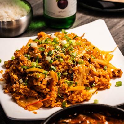 Spicy Korean kimchi fried rice topped with fresh green onions and sesame seeds.