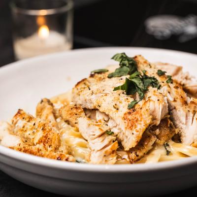 Fettuccine Alfredo topped with grilled chicken.