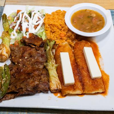 Bistek a la Tampiquena with enchiladas, rice, and beans.